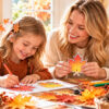 Western mother and daughter making colorful autumn leaf art at a sunny craft table